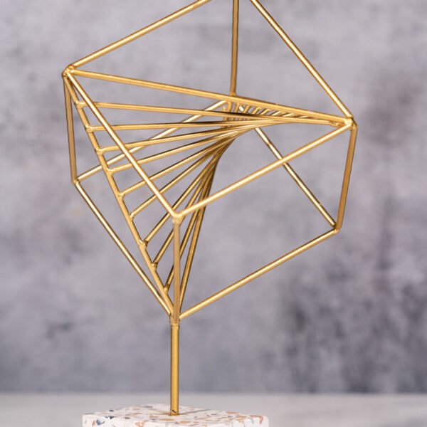 Elegant Gold Geometric Cube Sculpture with Spiraling Internal Structure on a Speckled Base, a Modern Abstract Tabletop Ornament