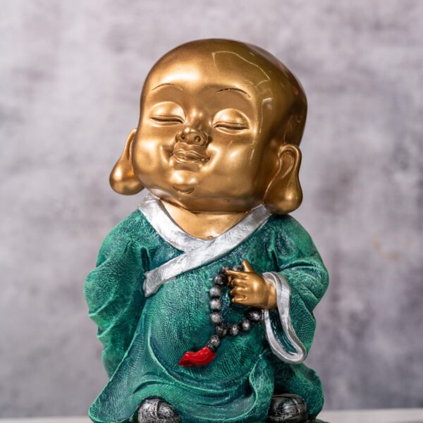 Serene Golden-Headed Baby Monk Statue in Green Robes Holding a Mala Symbolizing Peace and Good Fortune